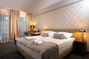 克拉科夫Xerion Hotel的酒店客房带一张大床,带毛巾