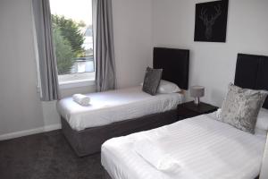福尔柯克Kelpies Serviced Apartments - McClean的酒店客房设有两张床和窗户。