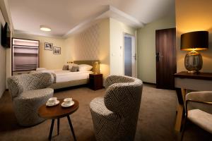 克拉科夫Xerion Hotel的酒店客房配有一张床、两把椅子和一张桌子