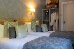 格伦加里夫Eccles Hotel and Spa的酒店客房设有两张床和一个衣柜。