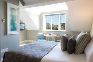 格伦加里夫Eccles Hotel and Spa的一间卧室设有一张大床和一个窗户。