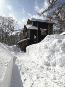 小谷村HIEDA SANSO的围栏旁的雪地房子