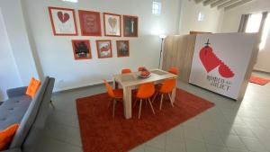 帕特雷Patras Romeο House的一间带桌子和橙色椅子的用餐室