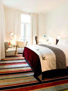 奥克兰德布雷特酒店的卧室配有床、椅子和窗户。