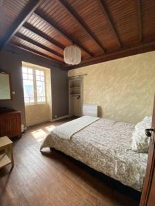 基伯龙LES CLAPOTIS RUE DU PHARE QUIBERON的一间卧室设有一张床和木制天花板