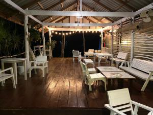 高兰BOHO Hostel的庭院配有白色的桌椅和灯具。