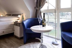富伦多夫Holiday house, Fuhlendorf的一间卧室配有一张床和一张桌子,并提供一瓶葡萄酒