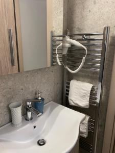 韦里亚Le Bijou Luxury Rooms & Suites的浴室配有盥洗盆、镜子和毛巾