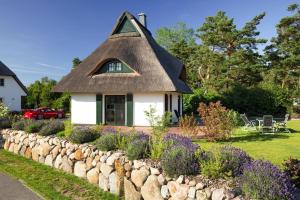 富伦多夫Holiday house, Fuhlendorf的小屋设有茅草屋顶和挡土墙