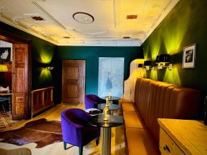 圣加伦基希Hotel Gasthof Adler的一间设有两张紫色椅子和一张桌子的房间