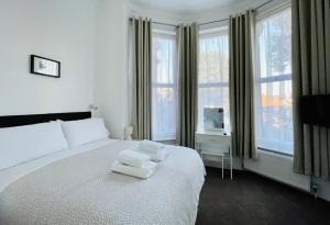 伦敦盖特威酒店的卧室配有白色的床和2条毛巾