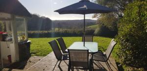 普里茅斯Quintessential, secluded South Devon cottage的庭院内桌椅和遮阳伞