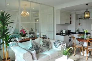 华欣Hua Hin-Summer Condominium的一间带白色沙发的客厅和一间厨房