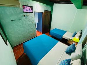 圣克里斯托瓦尔El Sol Posada的小房间设有两张床和窗户