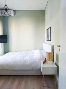 特里卡拉Hygge Home at Trikala的卧室配有白色的床和白色的桌子