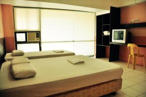 麦克坦拉普拉普城市GV酒店 的一间带大床和电视的卧室