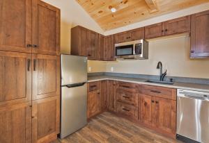 SunapeeThe Lodge by Sunapee Stays的厨房配有木制橱柜和不锈钢冰箱。