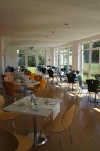 金茨堡宫兹伯格欧陆酒​​店的用餐室设有桌椅和窗户。
