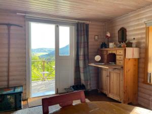 NordingråAteljéstugan med magisk utsikt的厨房设有大窗户,享有阳台的景色