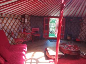 卡斯特拉讷艾罗斯山林小屋的蒙古包内的一个房间,配有沙发和一张桌子