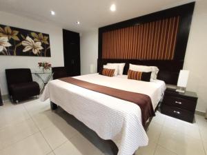 利马秘鲁蒙特瑞科酒店的一间卧室配有一张大床和一把椅子