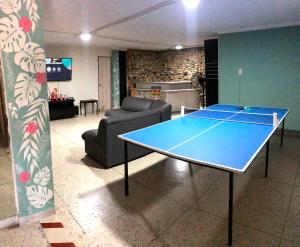 巴兰基亚La Quinta Bacana La Campiña的带沙发的客厅配有乒乓球桌
