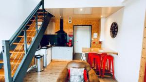 昂热Duplex industriel - Centre ville Parking privé WIFI的一间带楼梯的厨房和一间带红色凳子的厨房