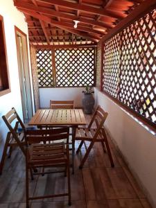 古里里Pousada Maresias Guriri的窗户间里的一张木桌和椅子