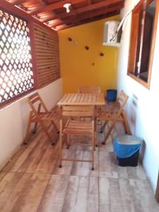 古里里Pousada Maresias Guriri的带庭院的客房内的一张木桌和椅子