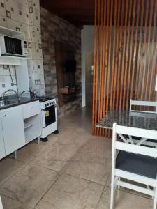 瓜尔达恩巴Moradas Jeane的厨房配有炉灶、水槽和桌子
