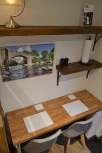 英格尔顿Dalecote Barn Bed and Breakfast (Bunkroom)的一张木桌、两把椅子和一张墙上的照片