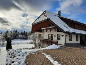 IbachHubertus Lodge的砖路上有雪盖屋顶的房子