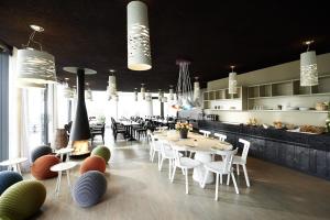赖兴瑙美音瑟尔谷拉科酒店的一间带白色桌椅的餐厅和一间厨房