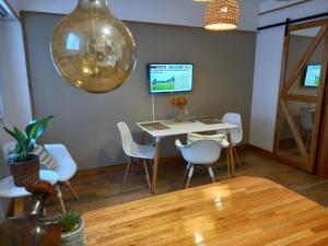 马德普拉塔DESCANSO IDEAL IV "el placer de los detalles"的一间带桌子和白色椅子的用餐室
