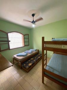 乌巴图巴Chalés Beto Amá的一间卧室设有两张双层床和吊扇