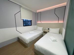 八打灵再也GG Hotel Bandar Sunway的小房间设有两张床和窗户