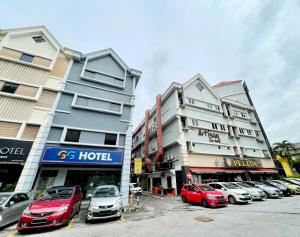 八打灵再也GG Hotel Bandar Sunway的停车场,停车场的汽车停在大楼前