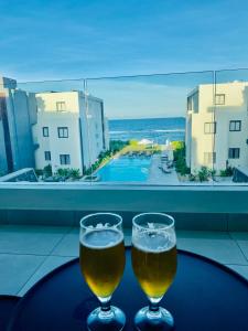 Poste LafayetteEastern Blue Beachfront Luxury Apartment的桌子上放着两杯啤酒,享有海景