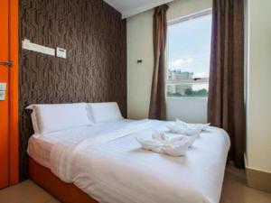 吉隆坡塔曼诺特1酒店的卧室配有白色的床和窗户
