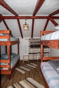 Proviţa de SusCabana „Stâna din Deal”的一间卧室设有两张双层床和吊灯。