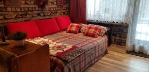 迈斯霍芬Maisalm, Apt 4的一间卧室设有红色的沙发和砖墙