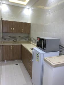 利雅德Elite Furnished Units的厨房配有白色冰箱和微波炉