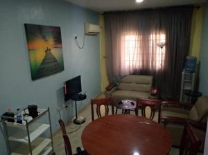 AbeokutaXrisBun Apt 1BR - Laderin GRA的客厅配有桌子和沙发