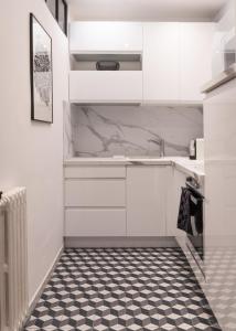 波城Magnolia : Superbe deux-pièces quartier du Château的厨房配有白色橱柜和黑白瓷砖地板。