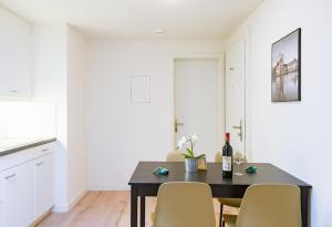 卢塞恩HITrental Zur Metzgern Apartments的餐桌、椅子和一瓶葡萄酒