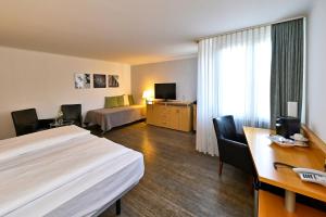 策勒HESSE HOTEL Celle的配有一张床和一张书桌的酒店客房