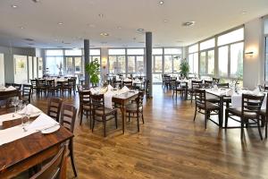 策勒HESSE HOTEL Celle的用餐室设有桌椅和窗户。