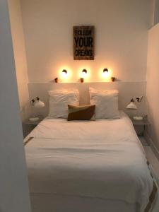 马赛圣特公寓的一间卧室配有白色的床和两盏灯