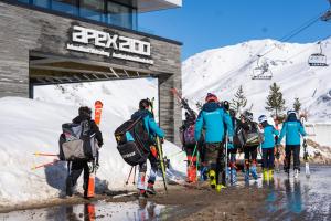 蒂涅Apex2100 International Ski Academy Tignes的一群人走向滑雪缆车