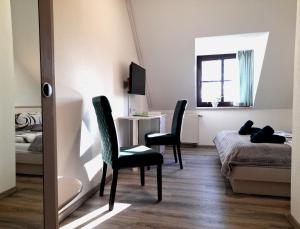科特布斯Hotel Zum Postkutscher的一间卧室配有一张床、一张桌子和两把椅子